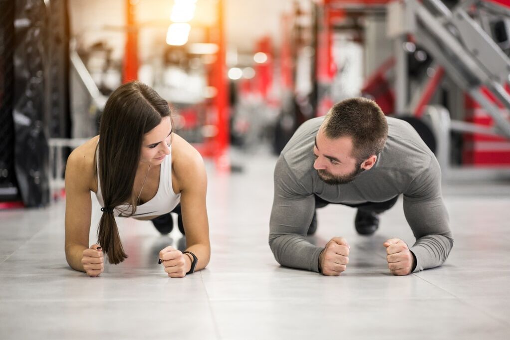 Seorang pria dan seorang wanita melakukan latihan Plank, yang dirancang untuk semua kelompok otot